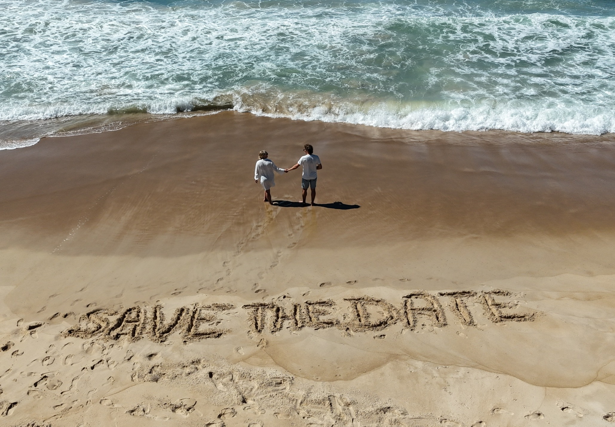 Laura and Rens on the beach — Save the Date 8 May 2027
